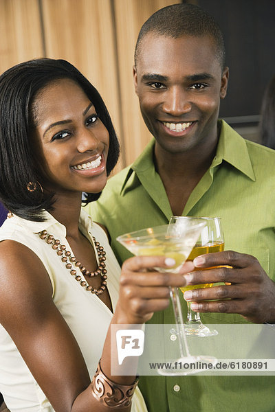 African couple toasting with cocktails
