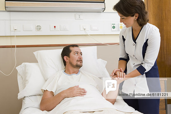 Nurse comforting patient in hospital room