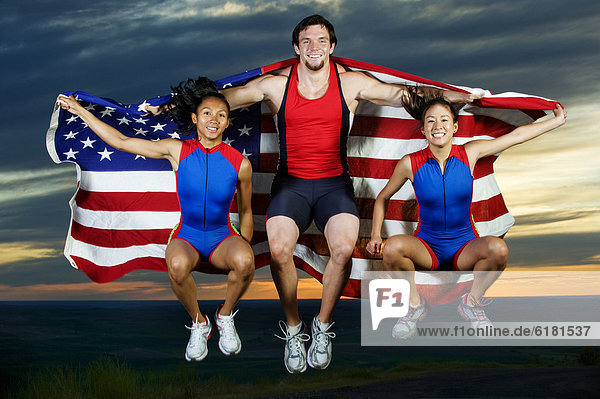 Athletes jumping in mid-air with American flag