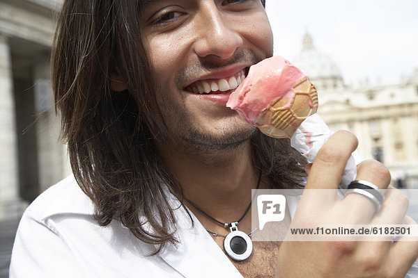 kegelförmig  Kegel  Mann  Eis  essen  essend  isst  Sahne  Italienisch