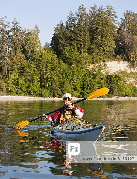 Hispanic woman kayaking on lake