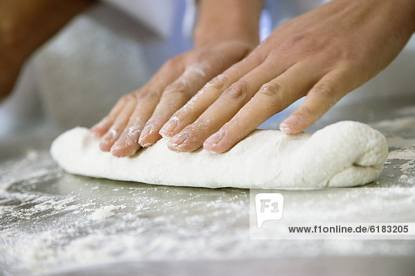 Close up of woman rolling dough