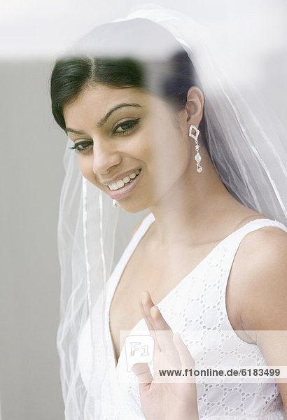 Mixed Race bride looking out window