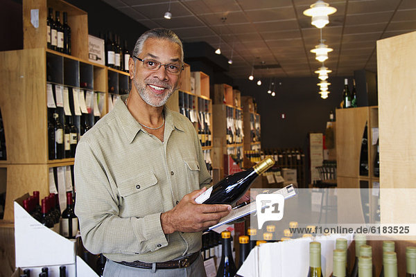 African American small business owner working in wine shop