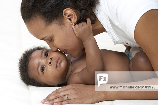 African American mother kissing baby
