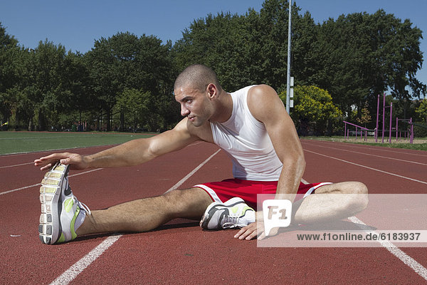 Mixed race runner stretching before race