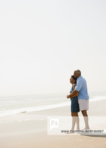 Black couple hugging on beach
