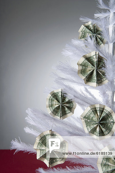 Cash ornaments on white  artificial Christmas tree