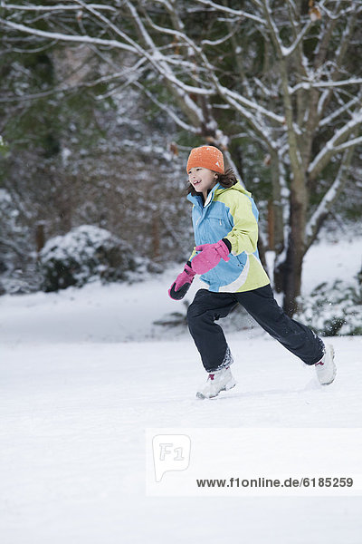 Mixed race girl running in snow