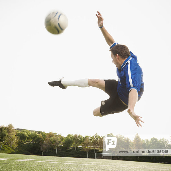 Europäer In der Luft schwebend treten Spiel Fußball Ball Spielzeug