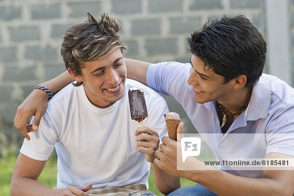 Hispanic men eating ice cream together