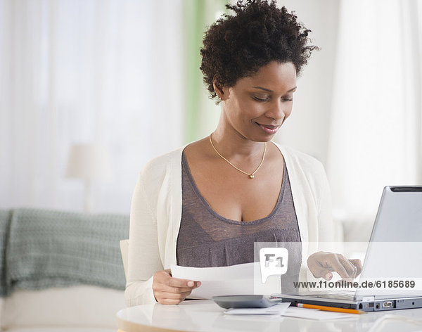 Black woman paying bills on computer