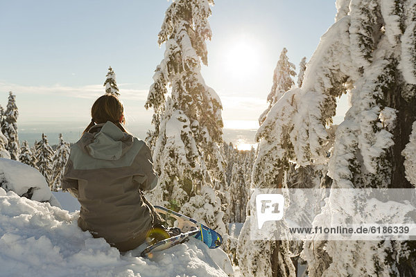 Caucasian woman snowshoeing in remote area taking break