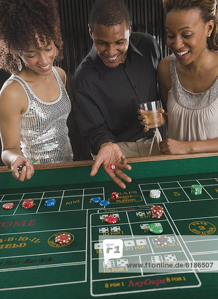African man and women playing craps at casino