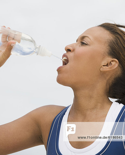 African woman drinking from water bottle