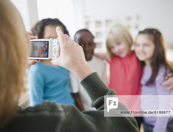 Girl taking photograph of friends with digital camera