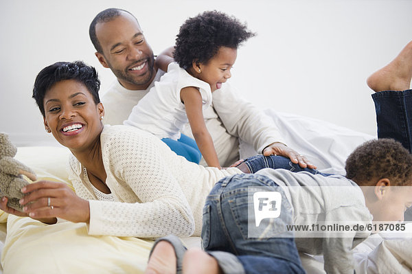 Black family laying on bed together