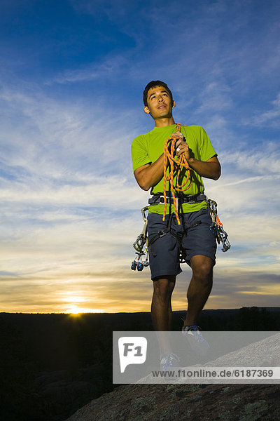 Hispanic man preparing for rock climbing
