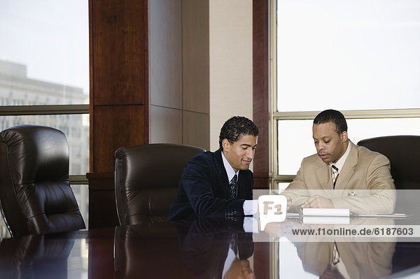 Two businessmen working in executive conference room