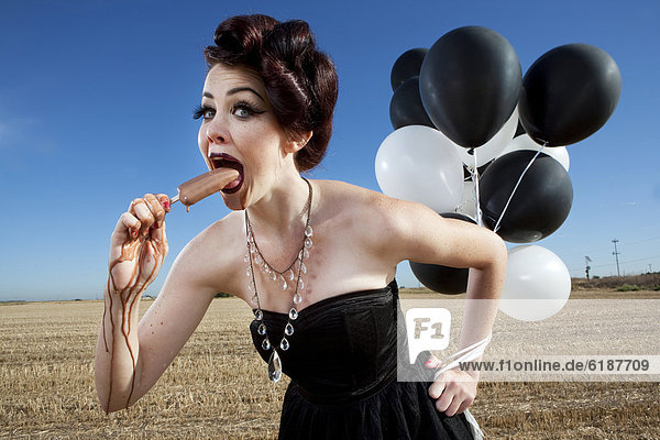 Eis am Stiel  Stieleis  Frau  Luftballon  Ballon  halten  Glamour  essen  essend  isst