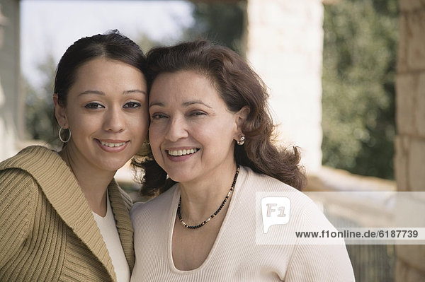 Multi-ethnic mother and daughter smiling