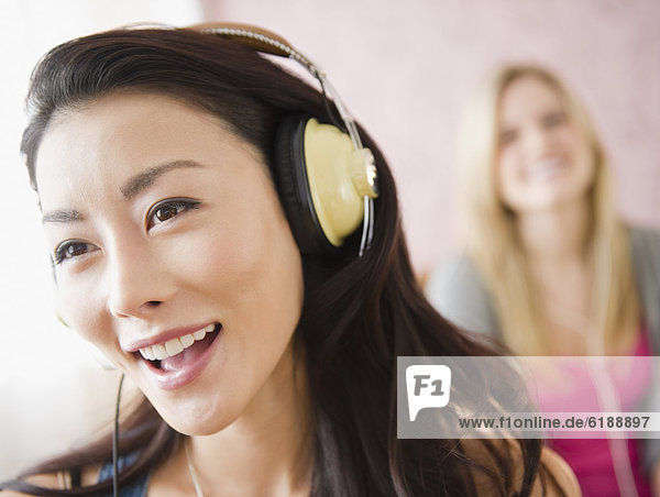 Asian woman listening to headphones