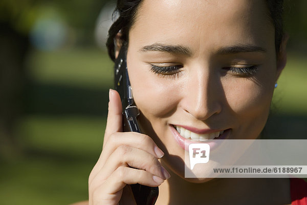 Close up of Hispanic woman talking on cell phone