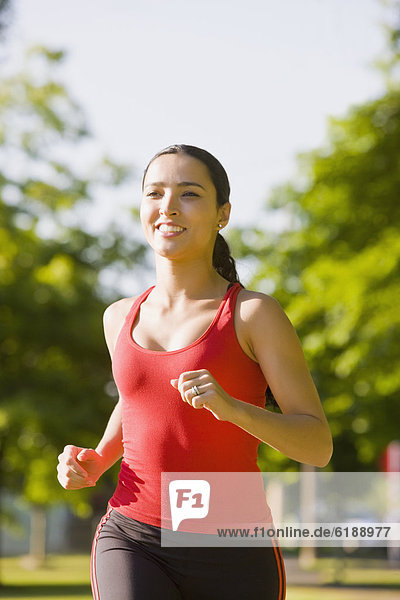 Hispanic woman jogging in park