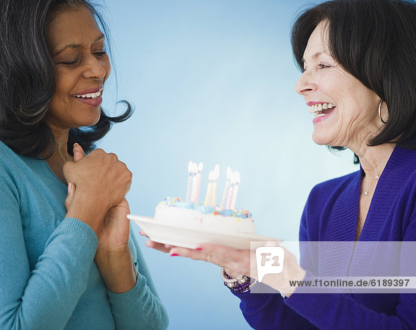 Woman surprising friend with birthday cake
