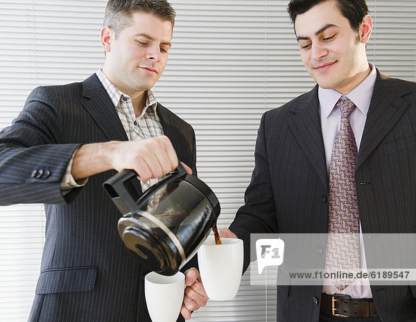 Geschäftsmann  Kollege  eingießen  einschenken  Kaffee