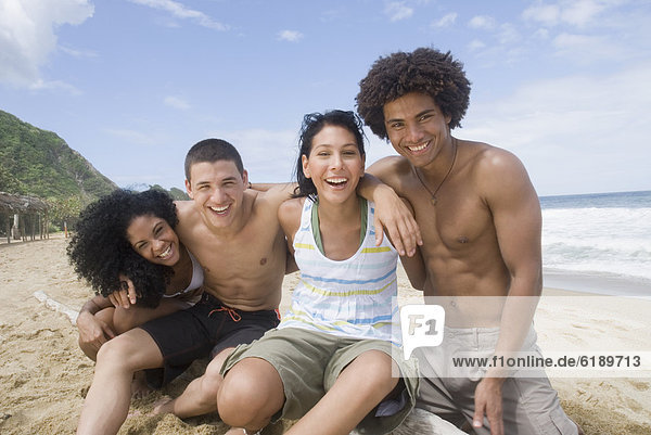 Multi-ethnic friends hugging at beach