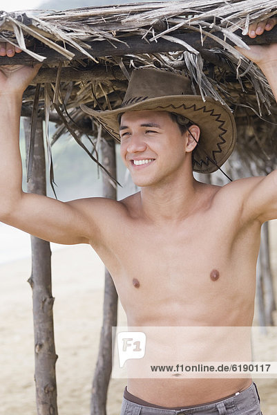Bare chested Hispanic man in cowboy hat