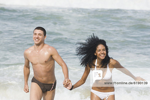 Multi-ethnic couple holding hands at beach