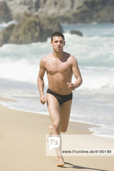 Hispanic teenager running on beach
