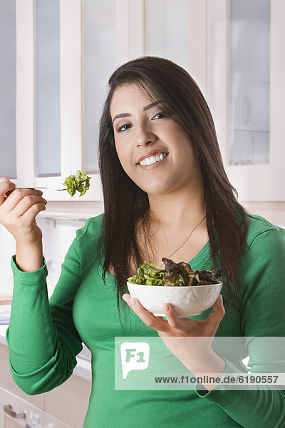 Hispanic woman eating salad