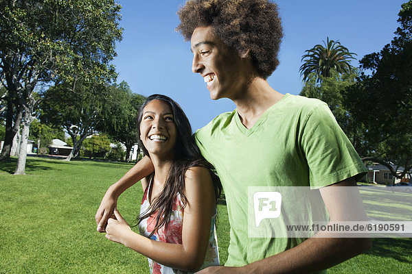 Teenage couple walking in park