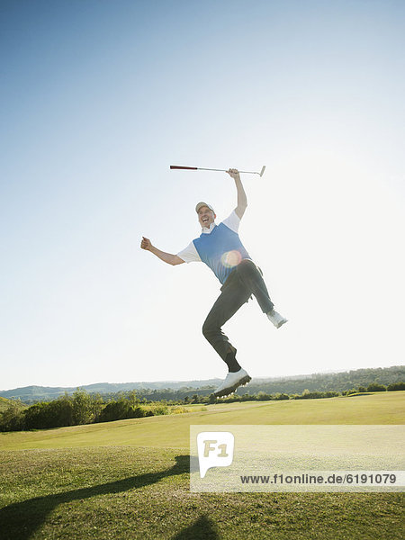 Europäer  In der Luft schwebend  Begeisterung  springen  Golfspieler  Golfsport  Golf  Kurs