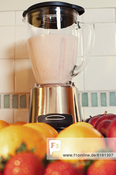Fruits and blender in kitchen counter