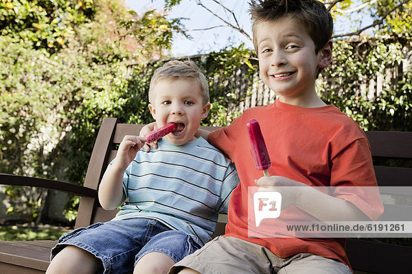 Caucasian brothers eating popsicles