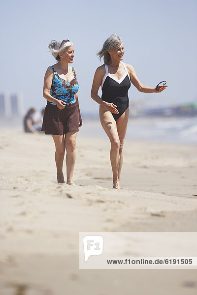 Friends in bathing suits walking on beach