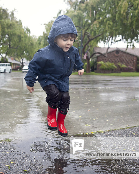 Europäer  Junge - Person  Regen  springen  Pfütze