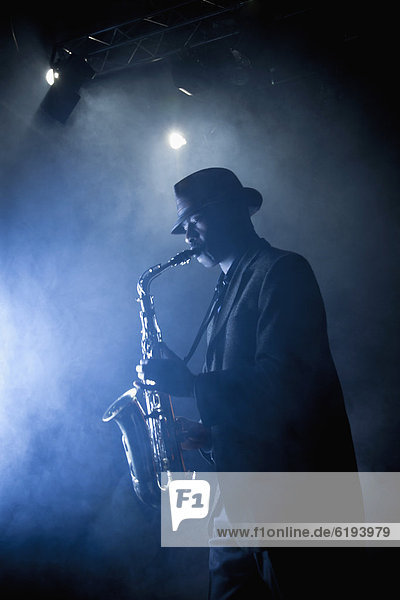 Black musician playing saxophone on stage