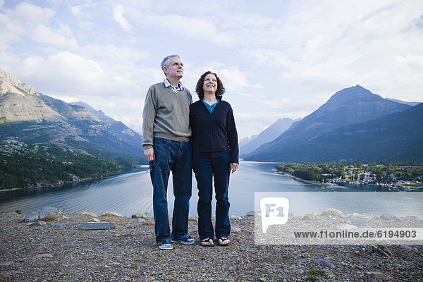 Caucasian couple standing outdoors with mountains in background