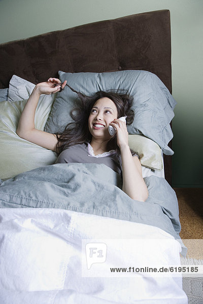 Frau sprechen am Telefon im Bett