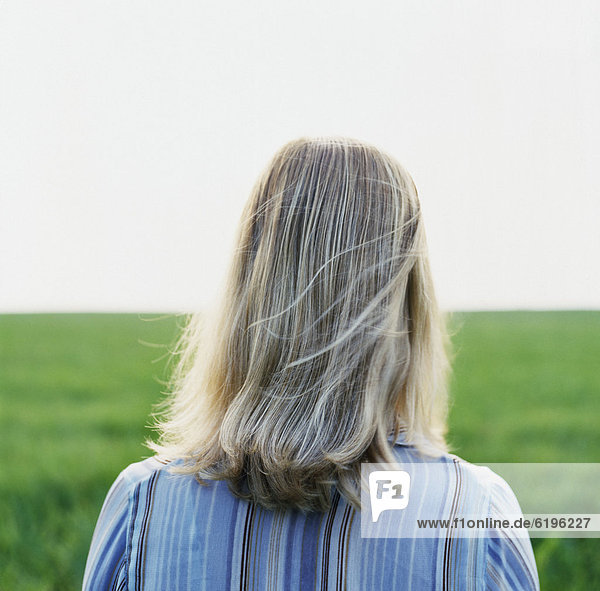 Caucasian woman standing in green field