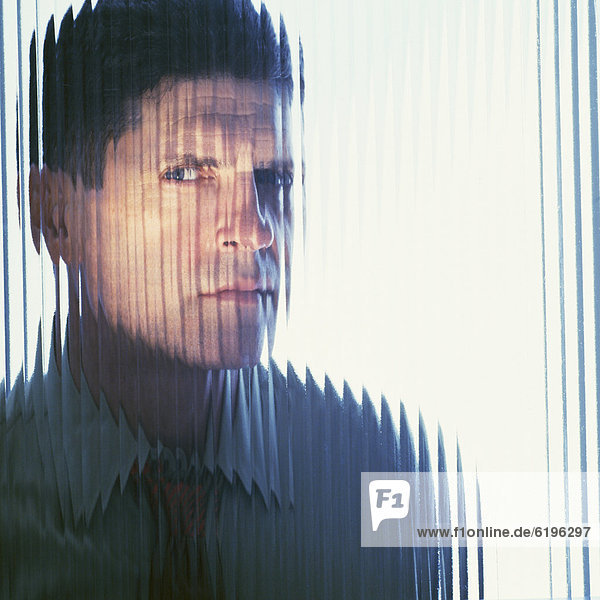 Suspicious businessman looking through glass wall
