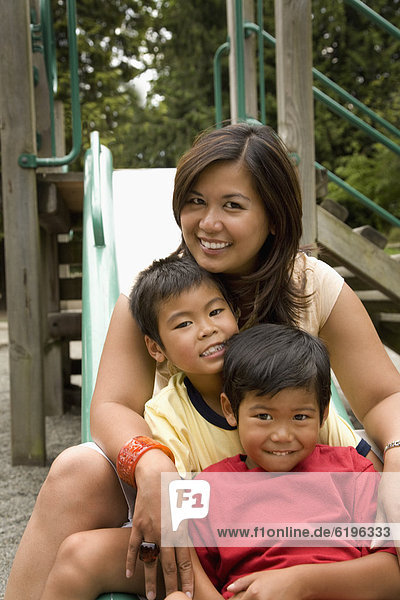 Asian family sitting together on slide