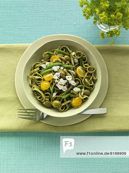 Pasta served with pesto  tomatoes and green beans