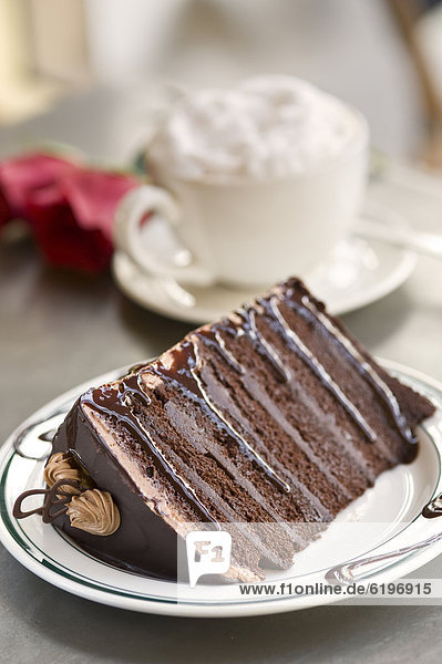Extravagant chocolate cake served with whipped cream topped coffee