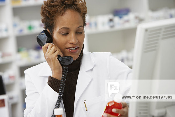 African female pharmacist talking on telephone